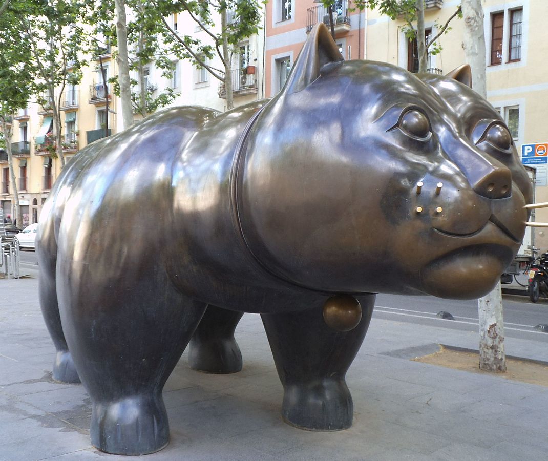 A majestic bronze cat sculpture in Fernando Botero’s signature voluminous style, displayed in a European plaza with classic architecture and warm sunlight.